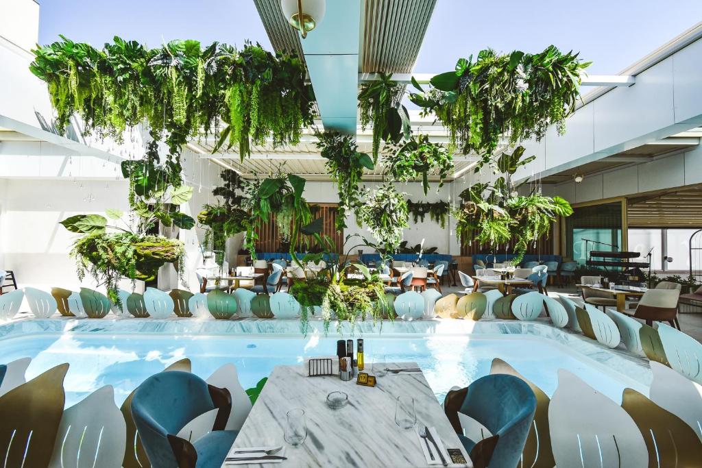 a large pool in a room with plants at Vila Reyna in Constanţa