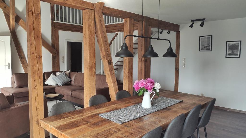 a dining room table with a vase of flowers on it at Ferienwohnungen in ausgebauter Scheune mit Ostseenähe in Zarnekow