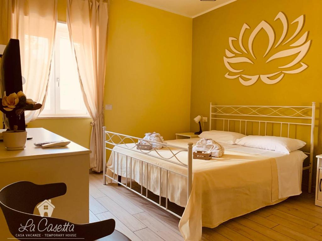 a bedroom with a bed with a yellow wall at La Casetta in SantʼEufemia Lamezia
