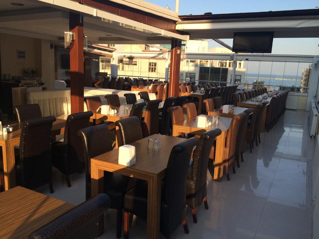 a dining room with wooden tables and chairs at Gloria Tibi Hotel in Samsun