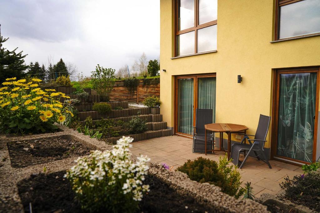 un patio con mesa y sillas junto a una casa en Fewo Hellerswiesen Arbeiterunterkunft en Bahretal