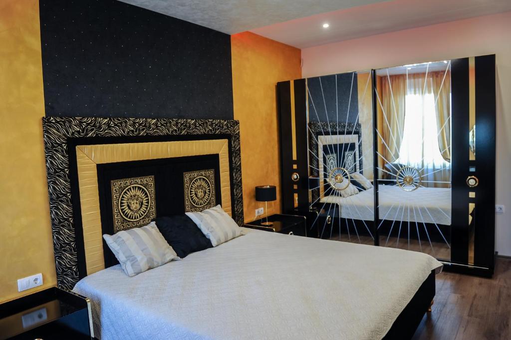 um quarto com uma grande cama branca e uma janela em Apartmani President I em Banja Luka