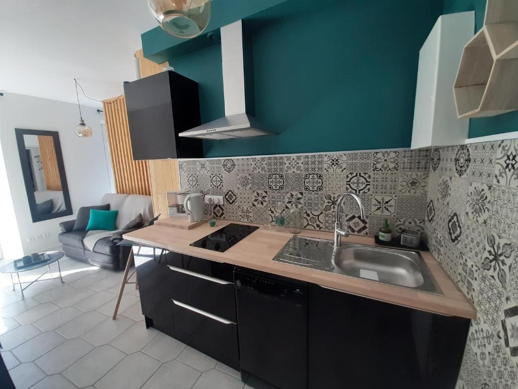 a kitchen with a sink and a counter top at Beau studio avec balcon in Bagnères-de-Bigorre