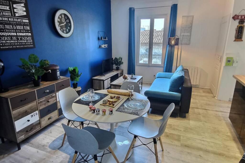 - un salon bleu avec une table et des chaises dans l'établissement L'INDUSTRIAL - 500m Musée BD, à Angoulême