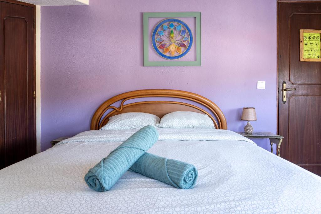 a blue pillow laying on a bed in a bedroom at Natural Mystic Hostel in Costa da Caparica
