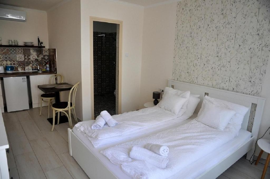 Un dormitorio con una cama blanca con toallas. en River Apartment, en Makó