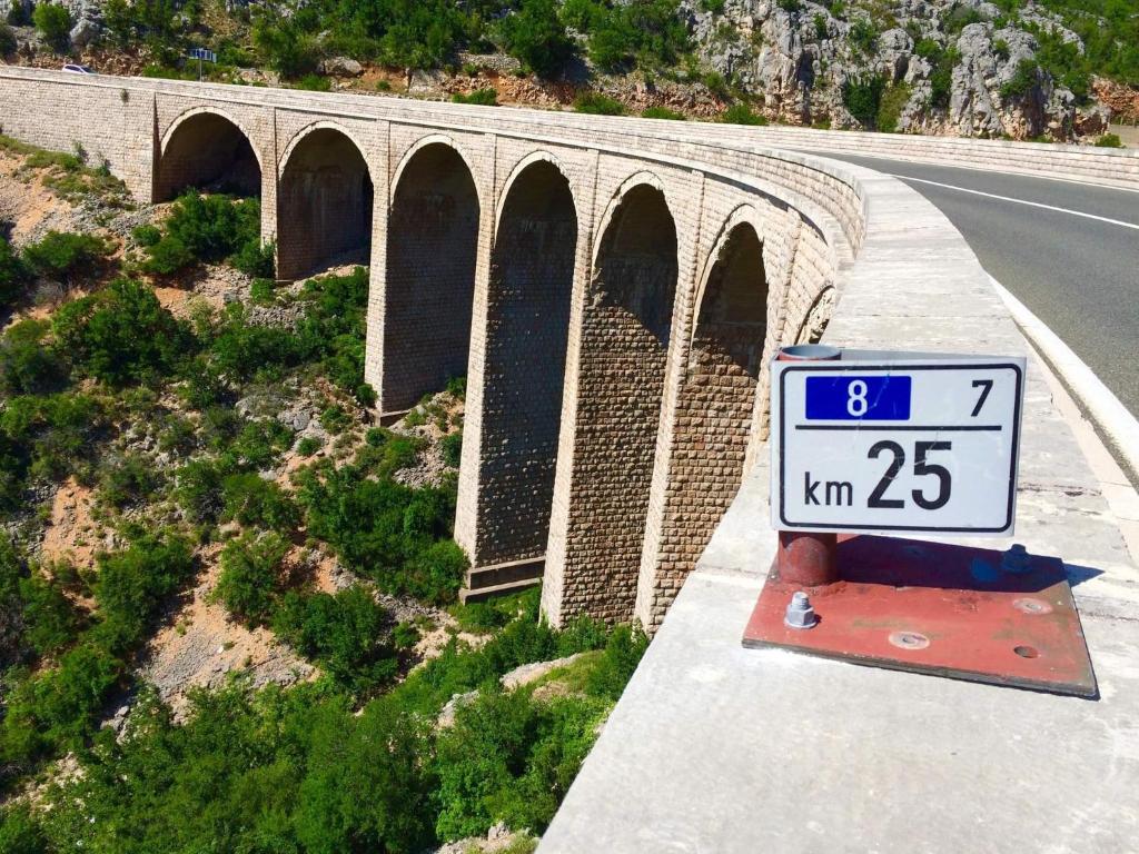 uma ponte com um sinal de limite de velocidade na berma de uma estrada em Apartment Modric em Senj
