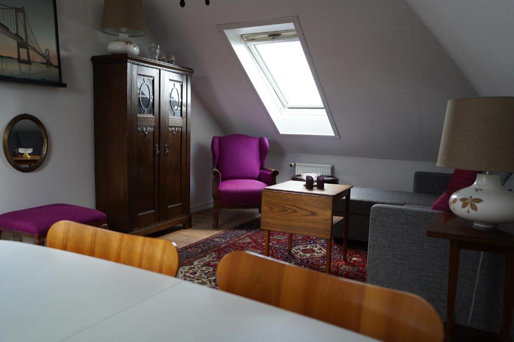 sala de estar con sillas moradas y sofá en Homely 2 room Apartment close to Copenhagen city center, en Copenhague