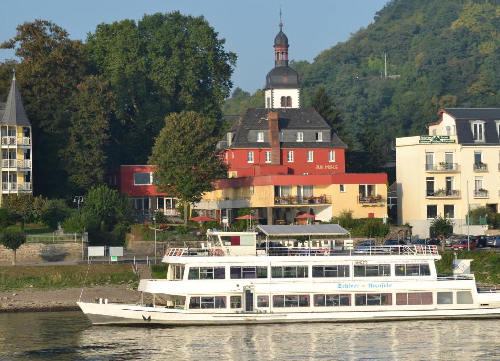 un barco blanco en el agua frente a los edificios en Hotel Zur Mühle, en Bad Breisig