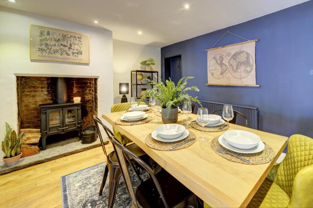 a dining room with a table and a fireplace at Church Bells House by Spa Town Property - 3 Bedroom Georgian Townhouse in Central Warwick in Warwick