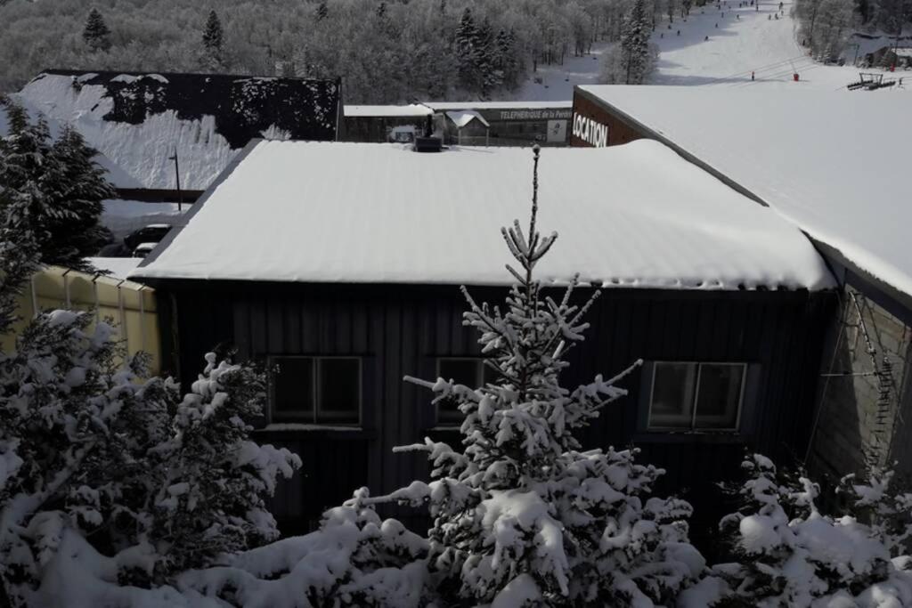 ein Haus mit Schnee auf dem Dach in der Unterkunft appartement 6 personnes au coeur de super besse in Besse-et-Saint-Anastaise