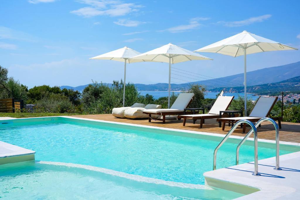 a swimming pool with two chairs and umbrellas at Videre Luxury Suites in Potos