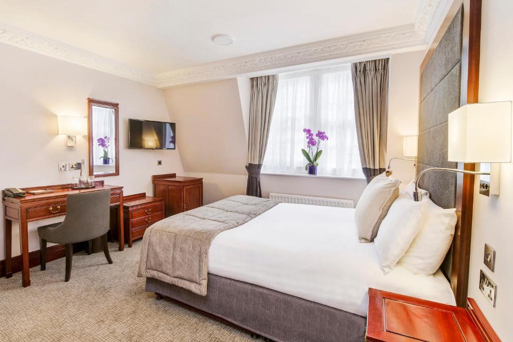 a hotel room with a bed and a desk at Gem Fitzrovia Hotel in London
