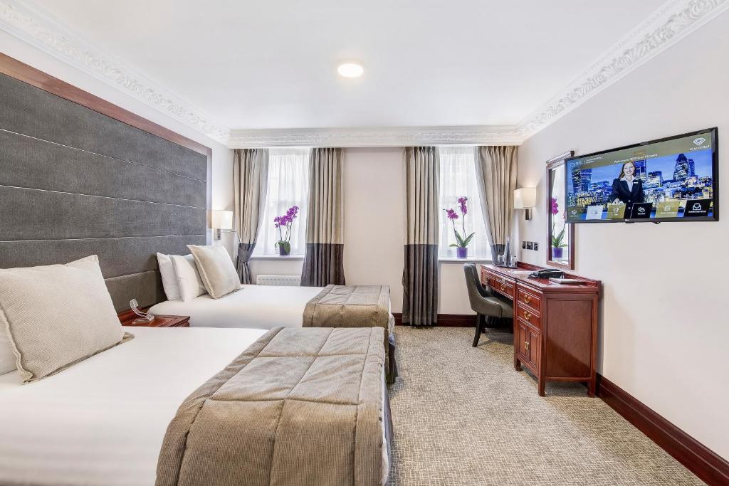 een hotelkamer met 2 bedden en een bureau bij Gem Fitzrovia Hotel in Londen