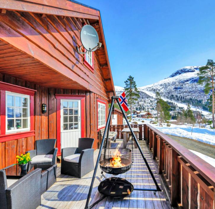 a porch of a house with a fire on it at Koselig Familie Hytte Hydla Stryn skisenter in Stryn