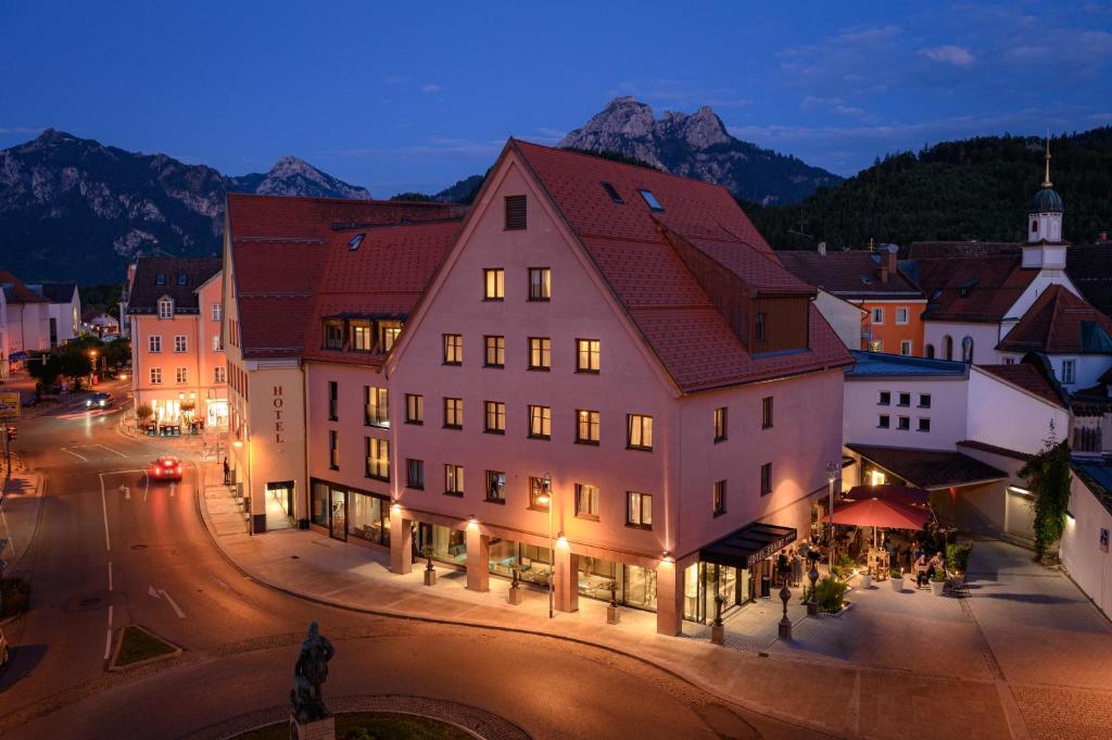 a town with buildings and a street at night at Hotel Sonne in Füssen