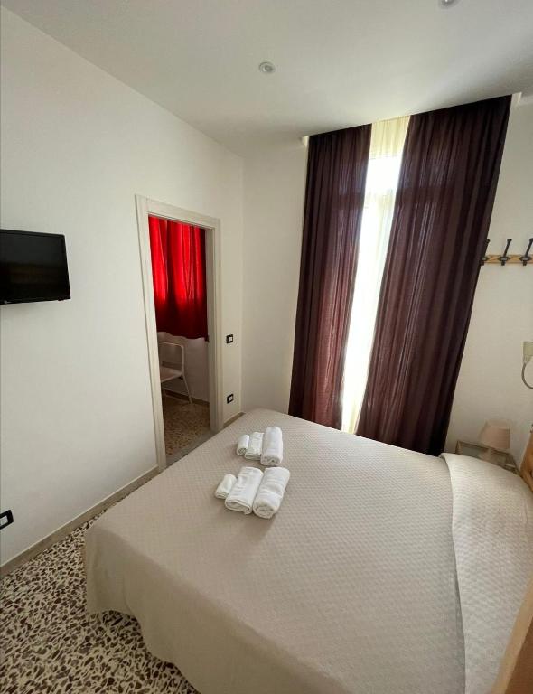 a bedroom with a white bed with towels on it at Donna Nunzia Home in Noto