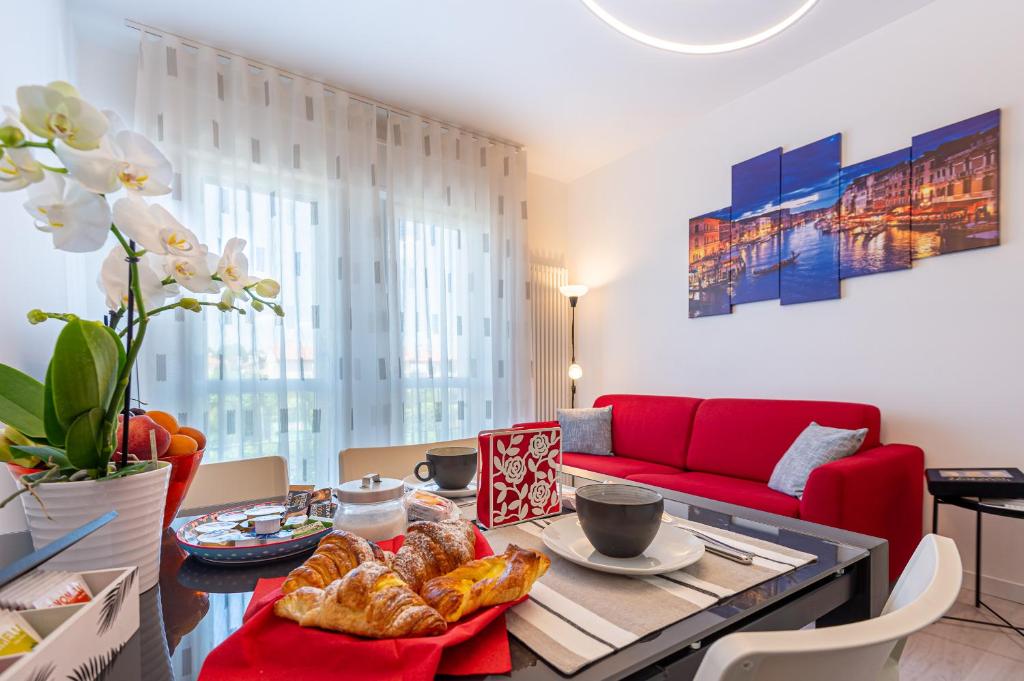 Casa Bastia في نوالي: غرفة معيشة مع أريكة حمراء وطاولة