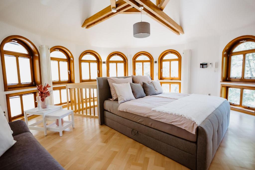 um quarto com uma cama, um sofá e janelas em Ferienwohnung Wasserturm Thale em Thale