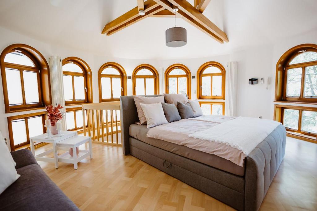 een slaapkamer met een bed, een bank en ramen bij Ferienwohnung Wasserturm Thale in Thale