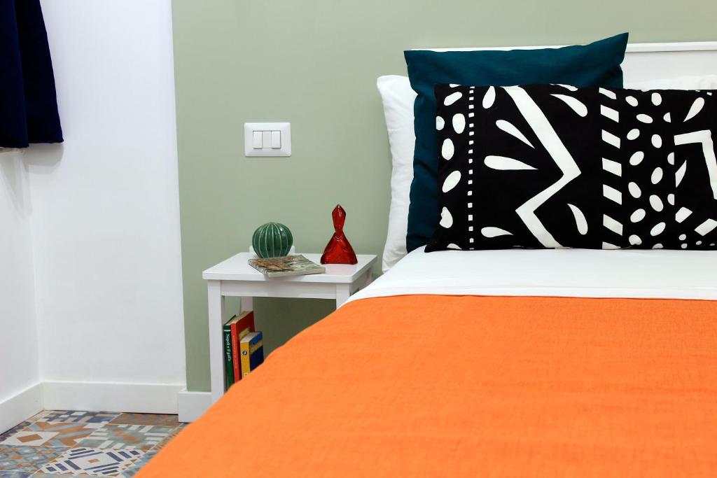 una camera da letto con un letto con un cuscino arancione e nero di Inner Naples a Napoli