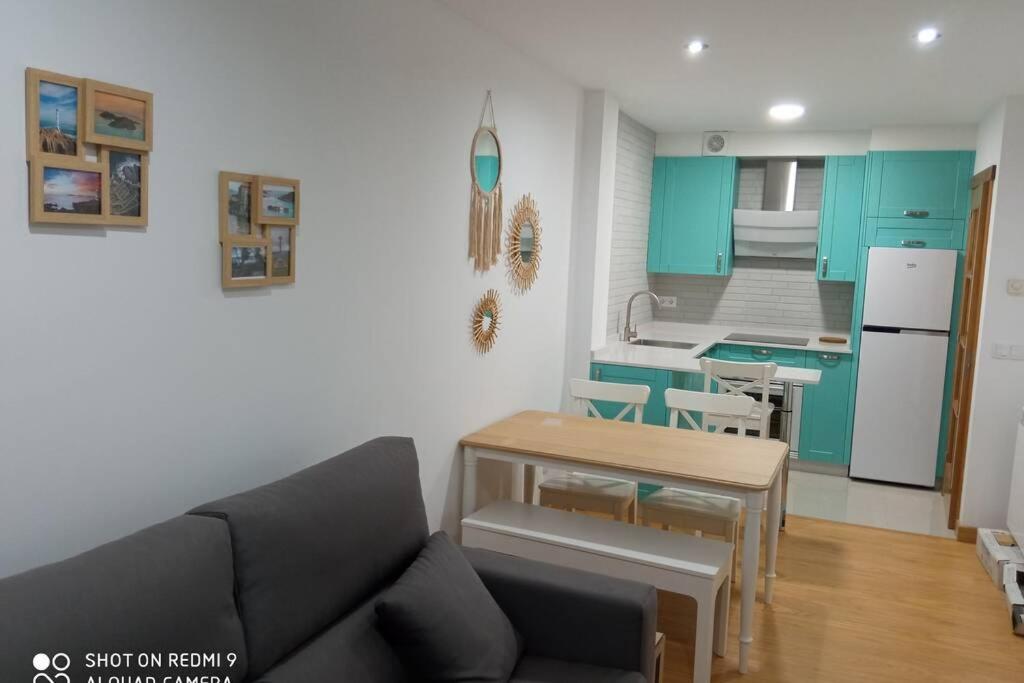 a living room with a couch and a kitchen at El pisito de Lourizan in Pontevedra