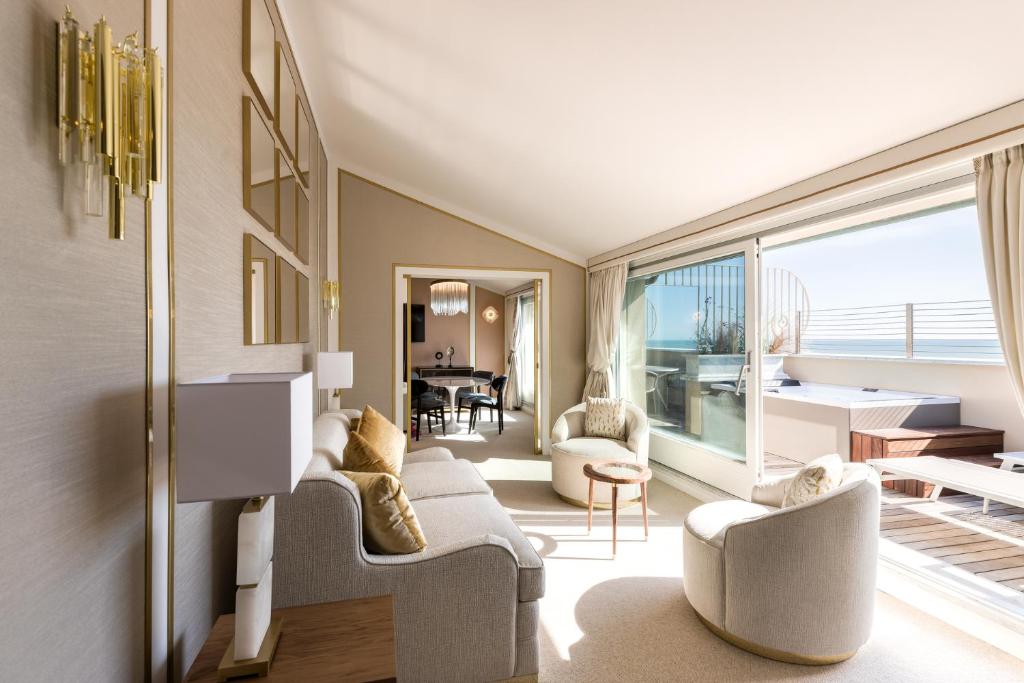 a living room with white furniture and a large window at Grand Hotel Principe Di Piemonte in Viareggio