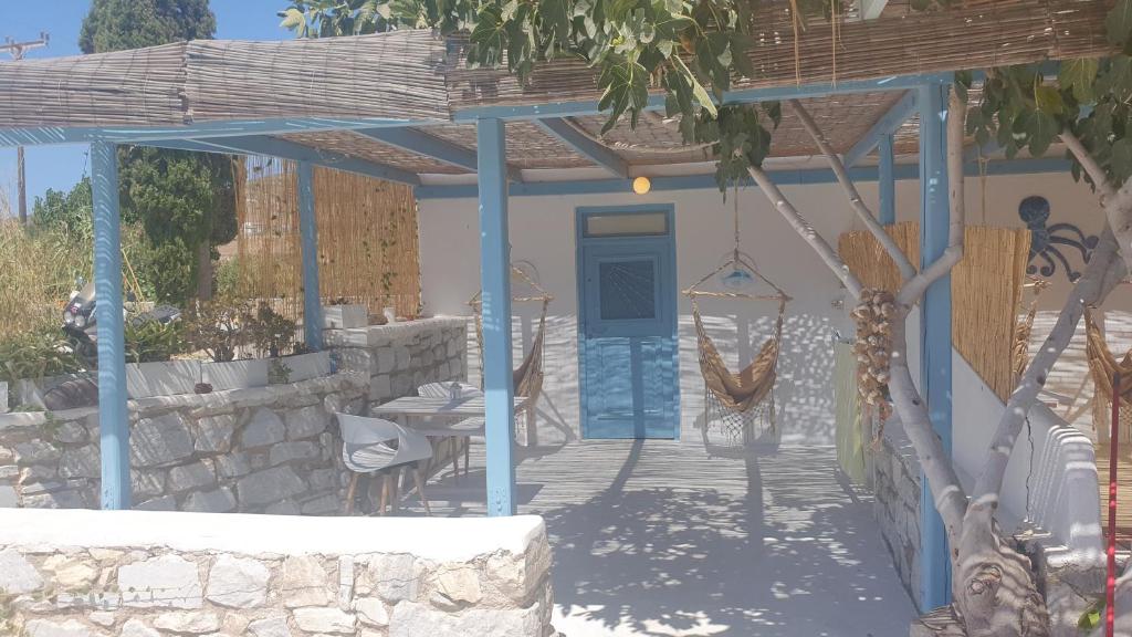 a house with a blue door and a porch with a hammock at Little Troll House 1 in Chrissi Akti