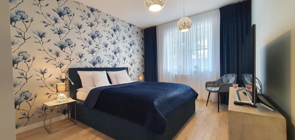 ein Schlafzimmer mit einem blauen Bett mit blau-weißer Tapete in der Unterkunft Apartement Insel Usedom Swinemünde in Świnoujście
