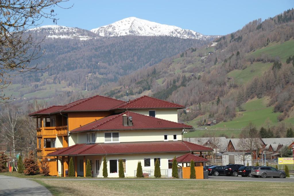 een groot huis met een berg op de achtergrond bij Pension Da Capo in Sankt Georgen ob Murau