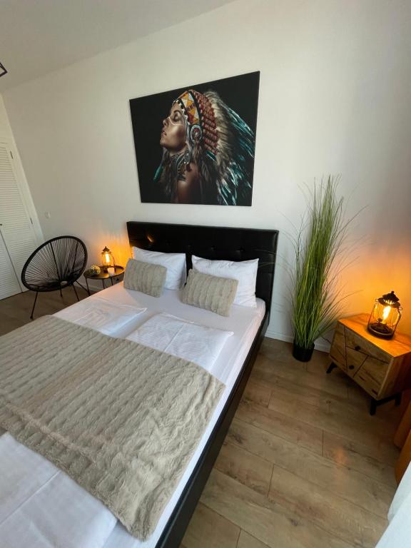 um quarto com uma cama com um quadro na parede em SOLE Apartment 2 em Satu Mare