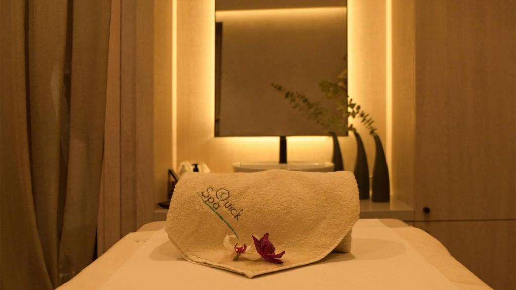 a white towel with flowers on top of a bed at Crowne Plaza Limassol by IHG in Limassol