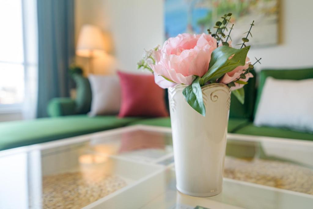 a vase with a pink flower sitting on a table at A'MORE Apartment in St. St. Constantine and Helena