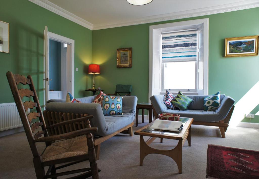 uma sala de estar com dois sofás e uma mesa em 17 William Street em Helensburgh