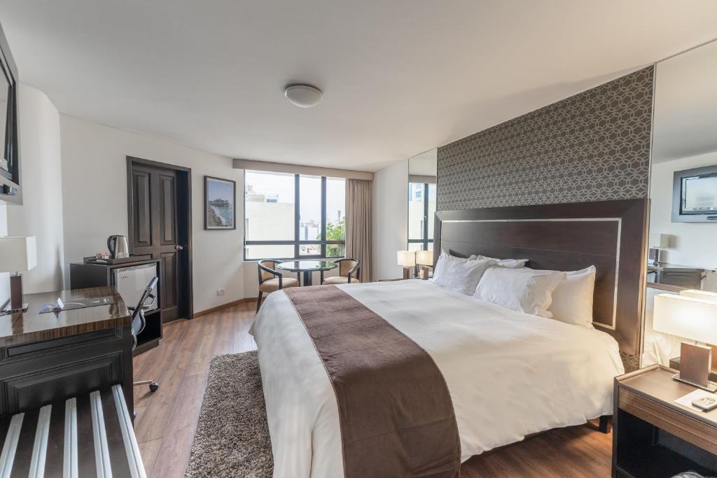 una camera d'albergo con un grande letto e una scrivania di Jose Antonio Executive a Lima