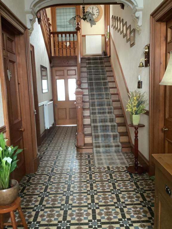a hallway with a tile floor and a staircase at Westlea Bed and Breakfast in Thurso