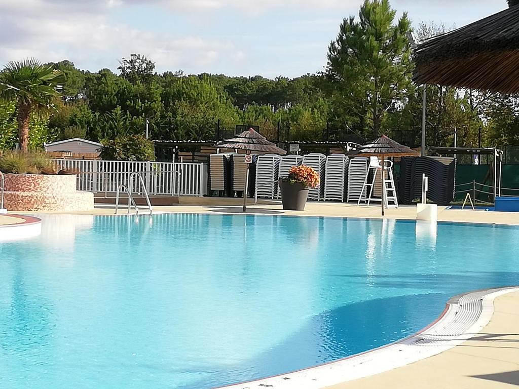 a large swimming pool with blue water at MOBILHOME GASTES LANDES in Gastes