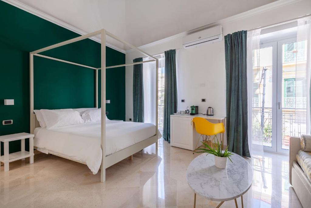 ein Schlafzimmer mit einem Himmelbett und einer grünen Wand in der Unterkunft Pompei Plaza in Pompei