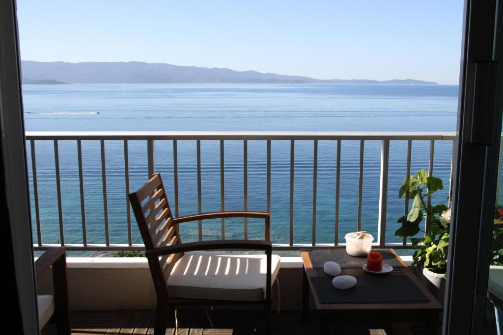 een balkon met een tafel en stoelen en uitzicht op de oceaan bij AjaccioPanoramicView in Ajaccio