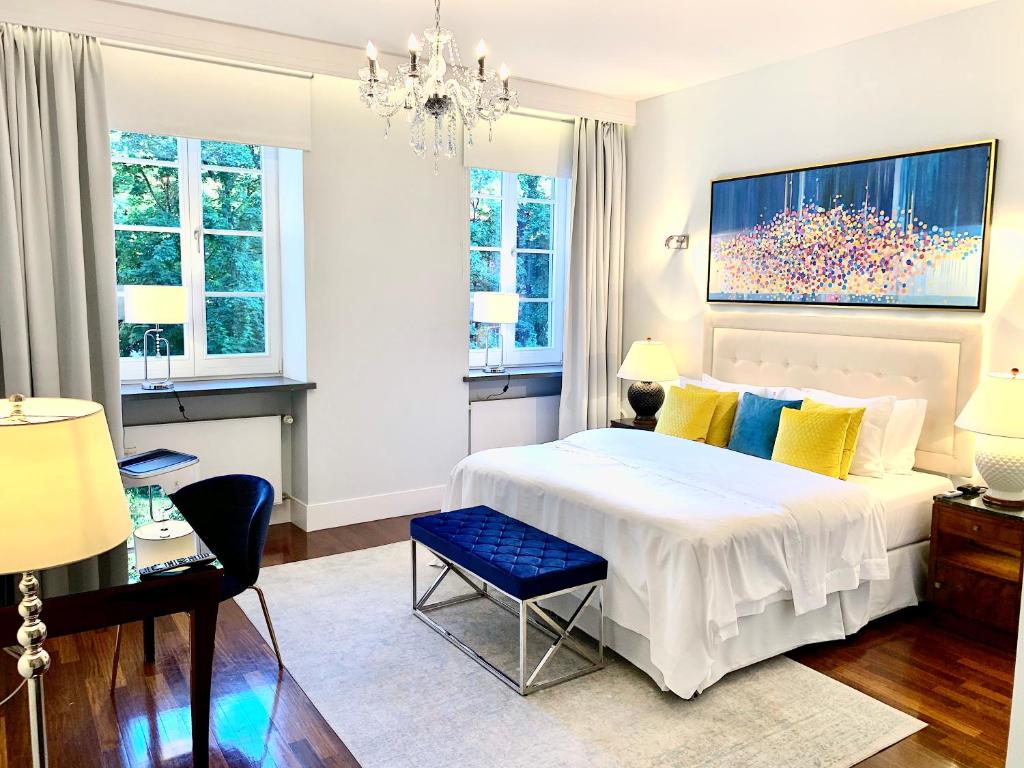- une chambre avec un grand lit blanc et un lustre dans l'établissement MONDRIAN Luxury Suites & Apartments Market Square I, à Varsovie