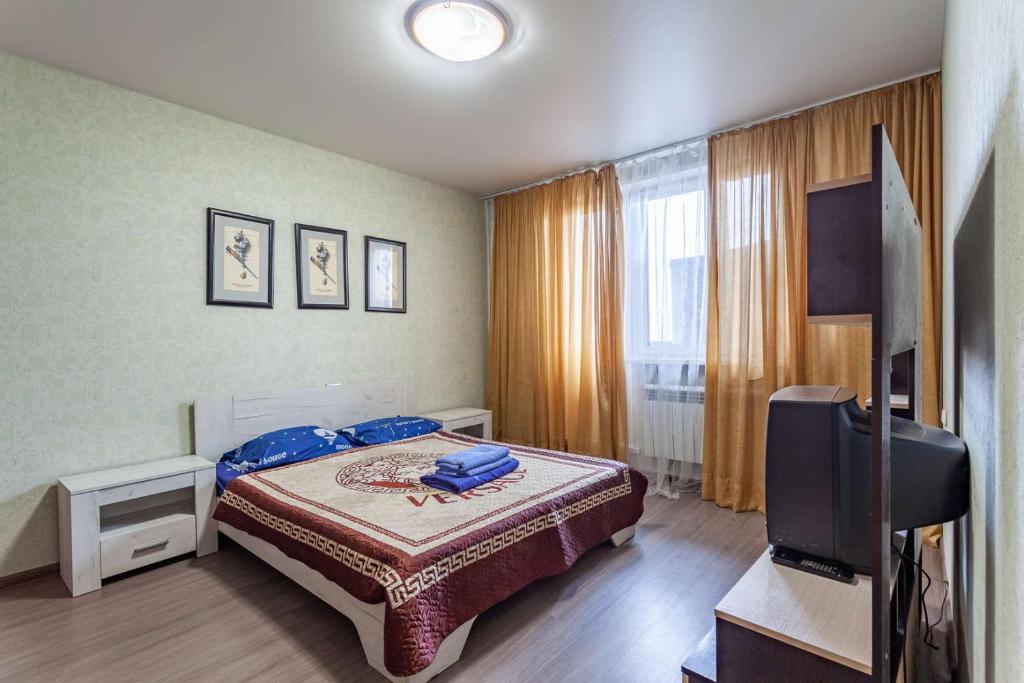 - une chambre avec un lit et une télévision à écran plat dans l'établissement Standard Brusnika Apartments Maryina Roshcha, à Moscou