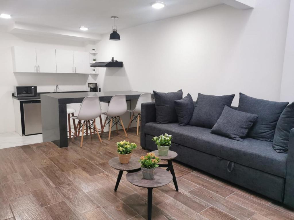 a living room with a couch and a kitchen at Loft Estancia Real in Morelia