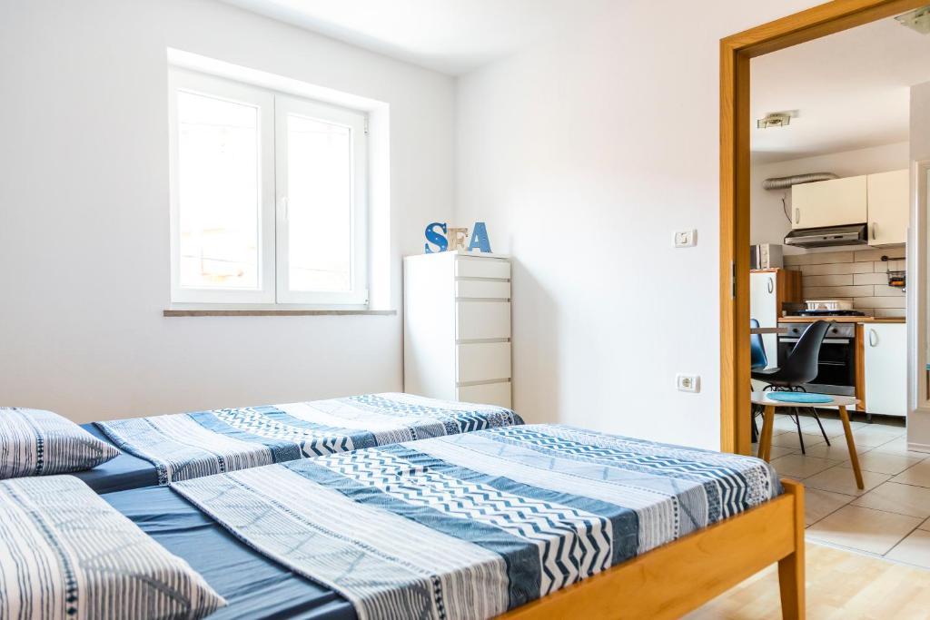 two beds in a room with a kitchen at Sunny Old Town Apartment in Koper