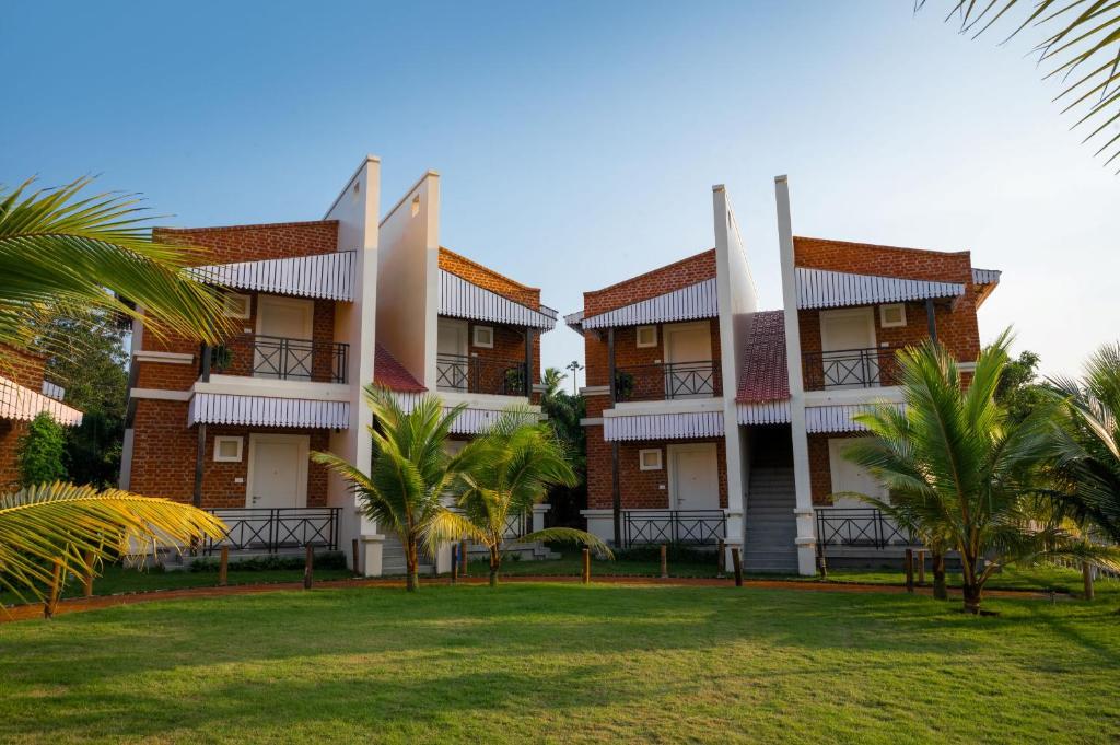 a building with palm trees in front of it at Jalchhabi Hotel & Resort in Lālbāgh