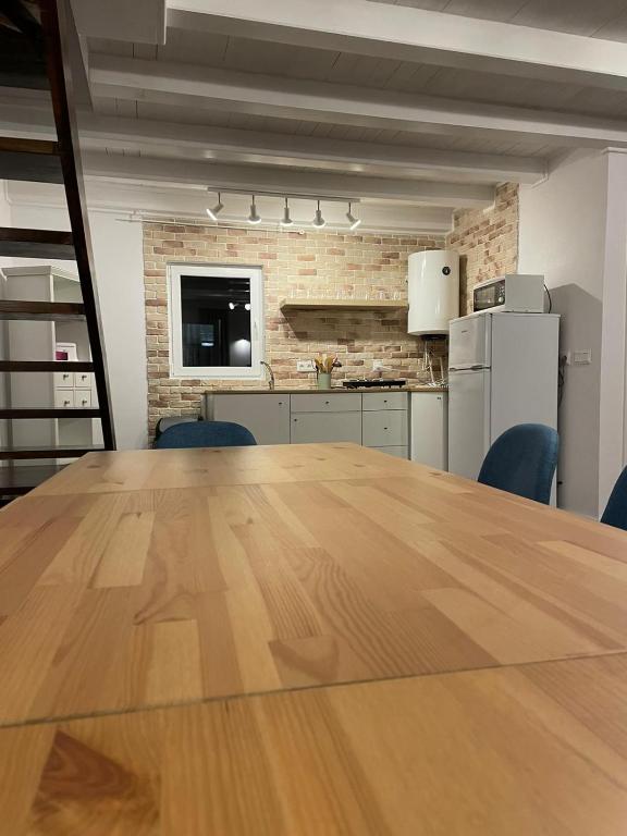 a large wooden table in a room with a kitchen at Cabana The Lux in Beclean
