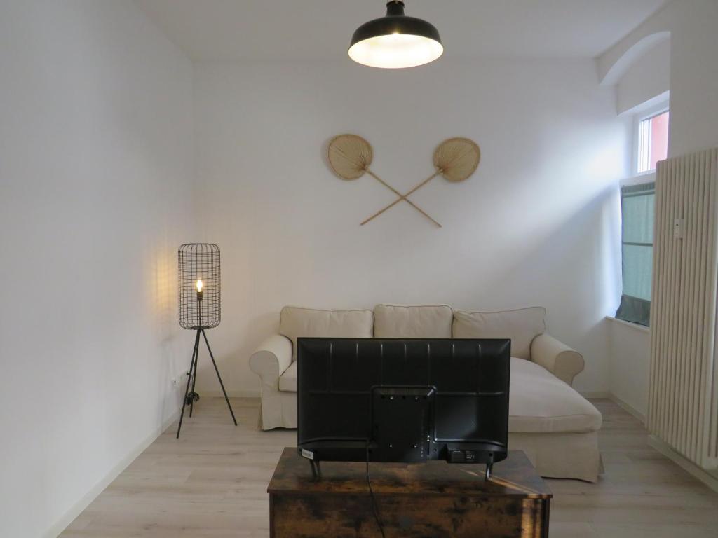 a living room with a couch and a clock on the wall at L8 Street - Mannheim Innenstadt in Mannheim