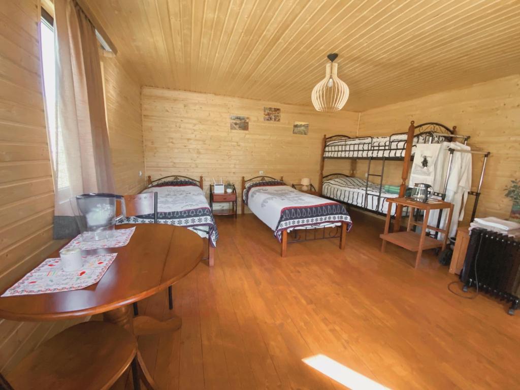 Zimmer mit 2 Betten und einem Tisch in der Unterkunft Ushguli Cabins in Uschguli