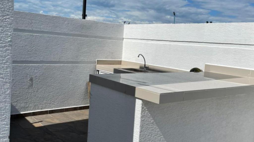 een wastafel aan de zijkant van een wit gebouw bij Casa Vacacional con Piscina Privada en Girardot in Girardot