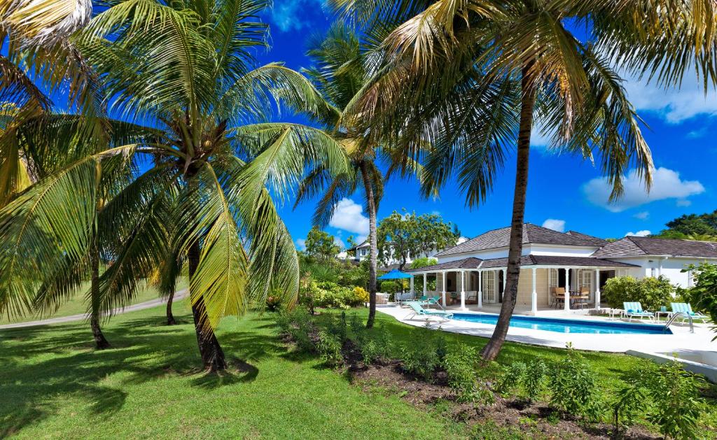 una casa con palmeras y piscina en Coconut Grove 1, Luxury Villa by Island Villas, en Saint James