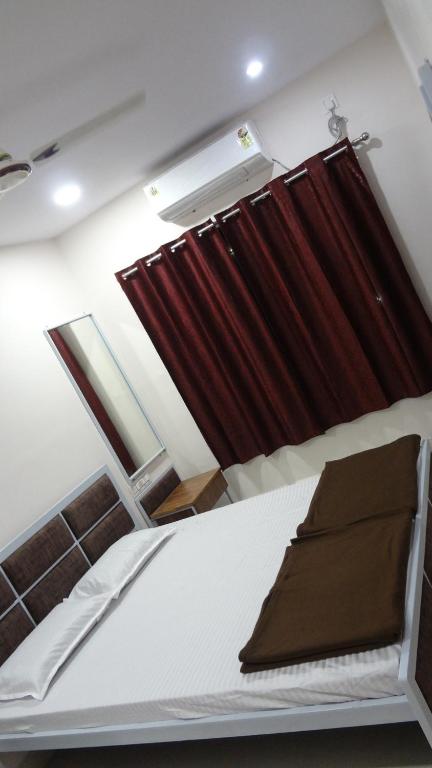 Bett in einem Zimmer mit einem roten Vorhang in der Unterkunft Anand P G hostel males only in Nagpur